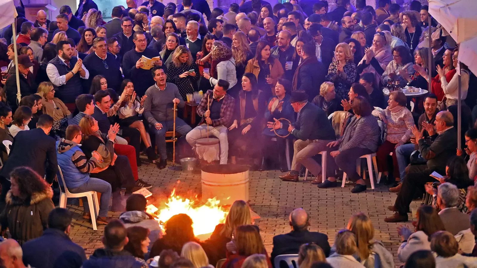 Grupo de personas cantando villancicos tradicionales en una zambomba jerezana con instrumentos folklóricos